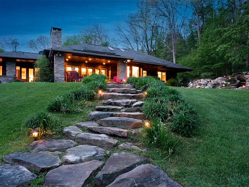Stone pathway leading to house with warm lighting